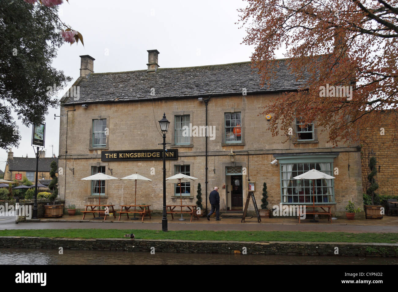 The Kingsbridge Inn public house beside the River Windrush in the