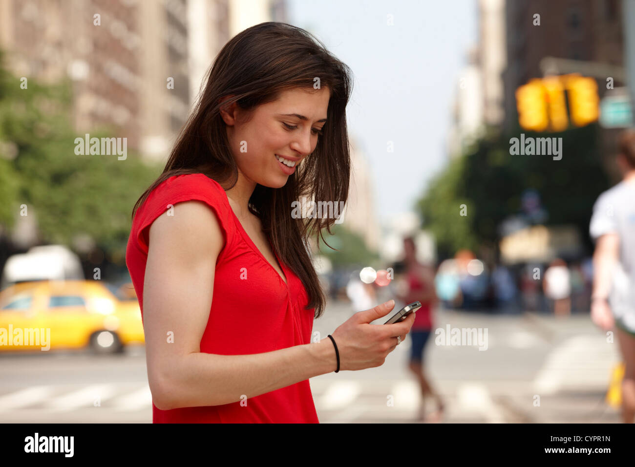 Caucasian woman using cell phone in city street Stock Photo