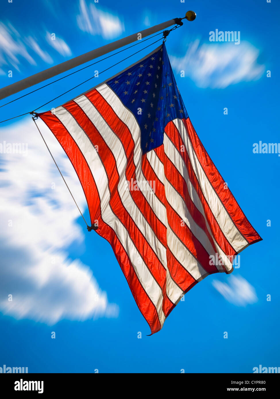 An american flag waving over a blue sky. Zooming effect. Stock Photo