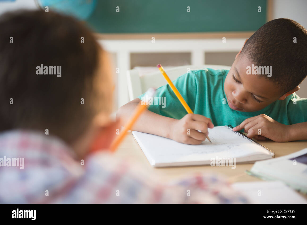 Children writing in classroom Stock Photo