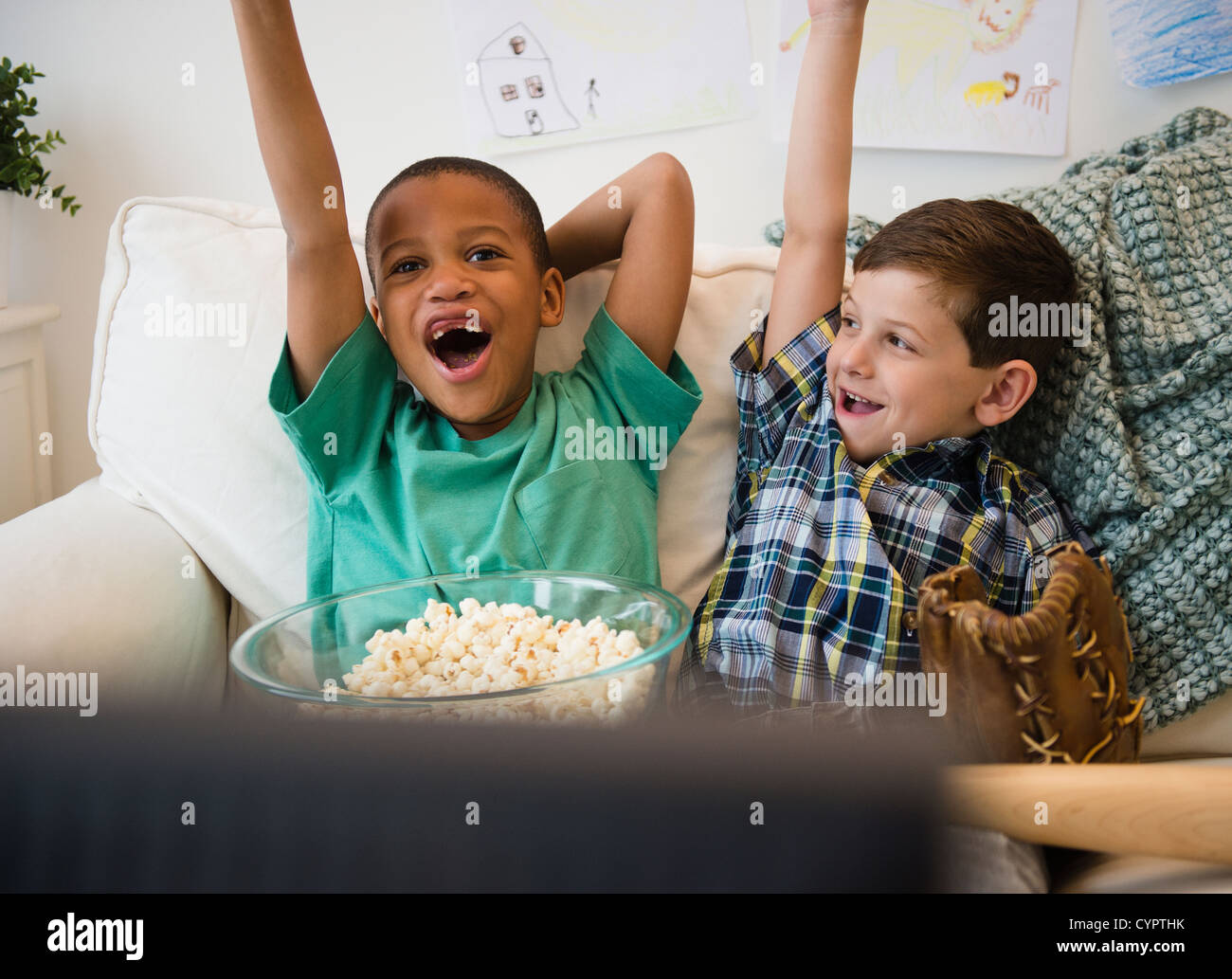 Boys eating popcorn and cheering Stock Photo