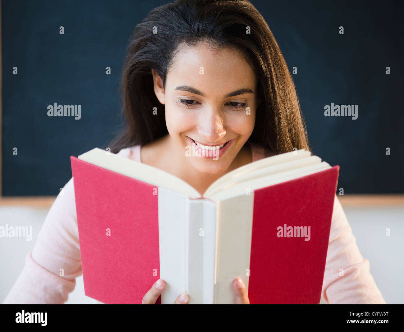 Hispanic teenager reading book Stock Photo