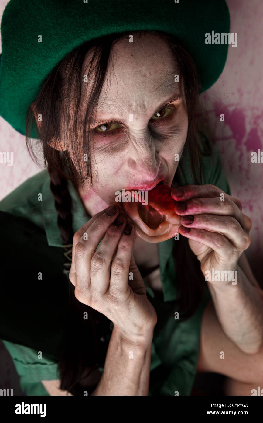 Scary zombie scout munching on a tasy human ear Stock Photo