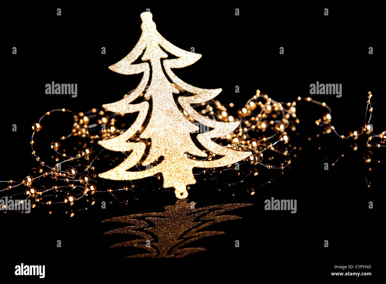 Gold Christmas tree with gold beads in the dark. Stock Photo