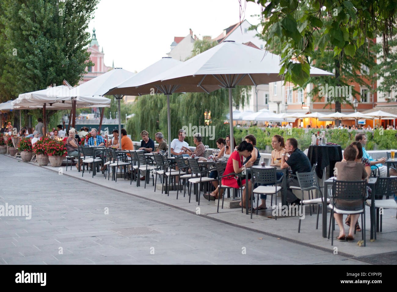 Sidewalk cafés on the banks of the Ljubljanica River in the old town in Ljubljana, the capital of Slovenia. Stock Photo
