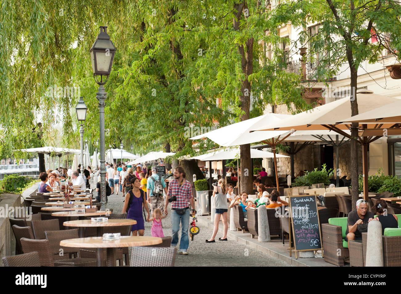 Sidewalk cafés on the banks of the Ljubljanica River in the old town in Ljubljana, the capital of Slovenia. Stock Photo