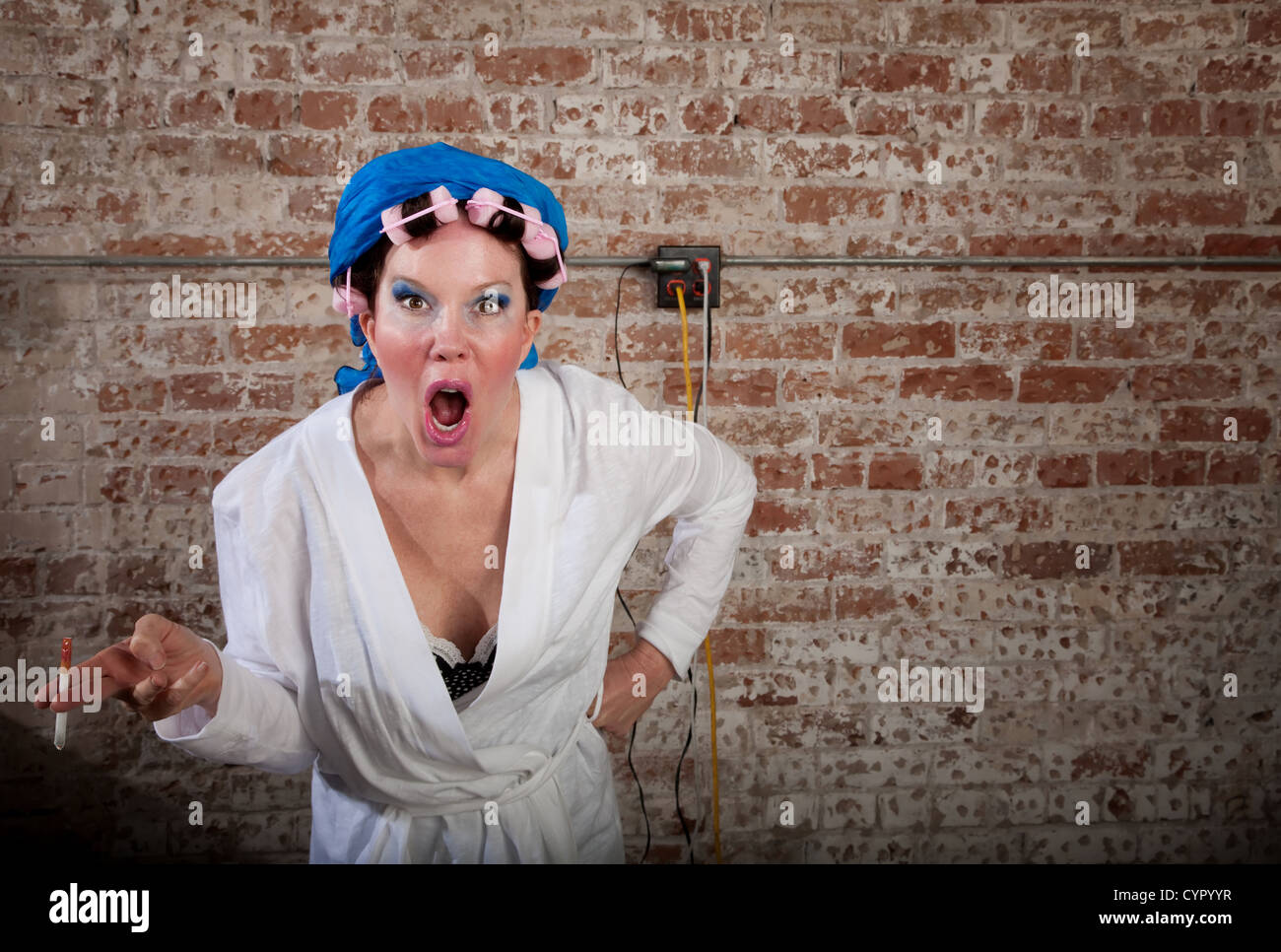 Upset lady with pink curlers and white robe Stock Photo - Alamy