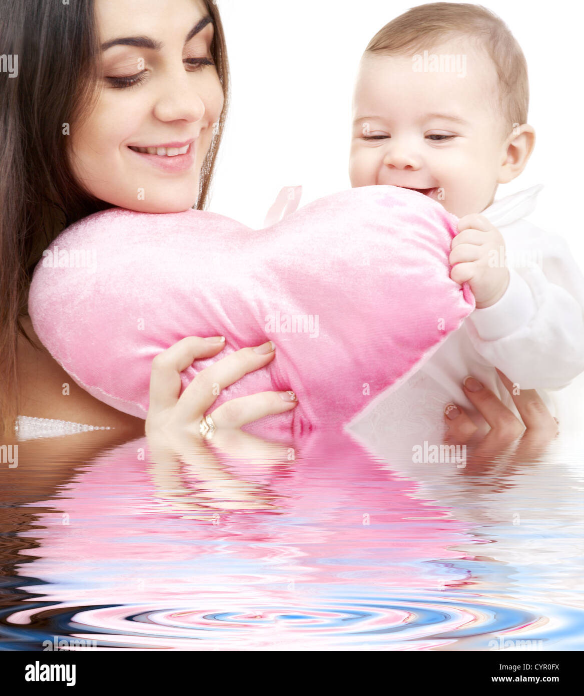 Happy Baby And Mama With Heart Shaped Pillow In Water Stock Photo
