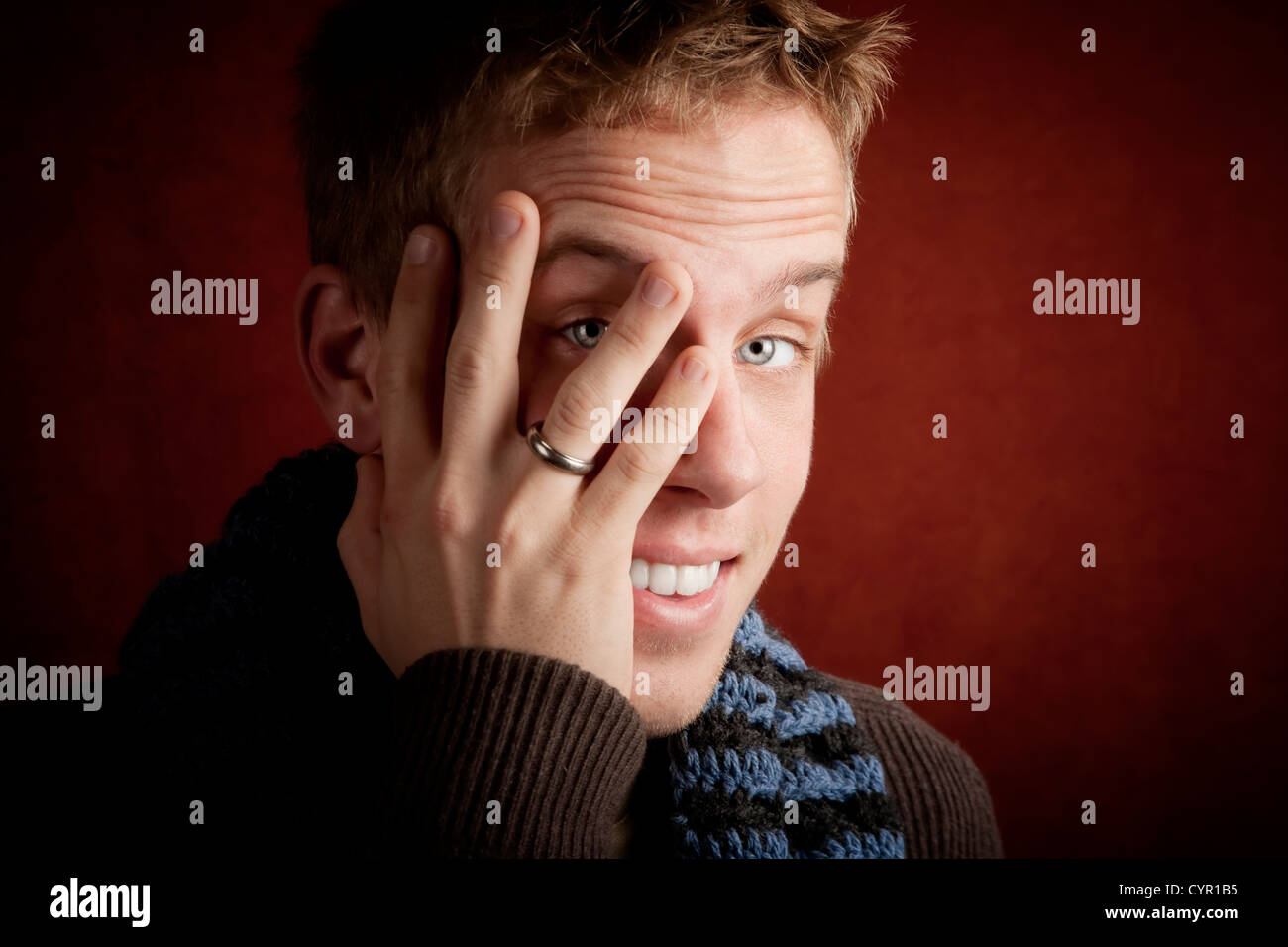 Young man covering face with his hand Stock Photo - Alamy