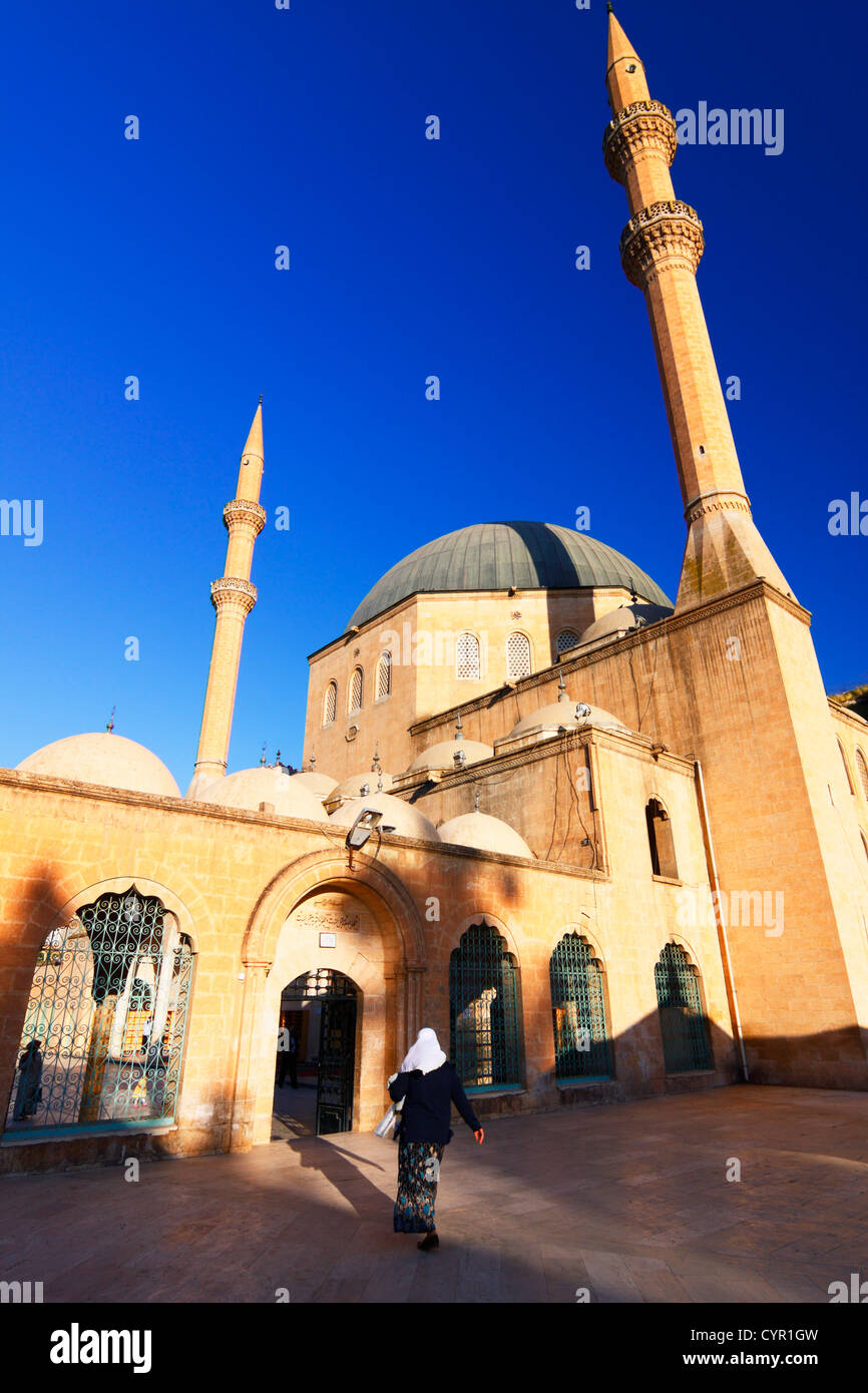 Woman with hejab entering the Mevlid-i Halil Camii mosque of the Degah complex by the Golbasi area of Sanliurfa, Turkey Stock Photo