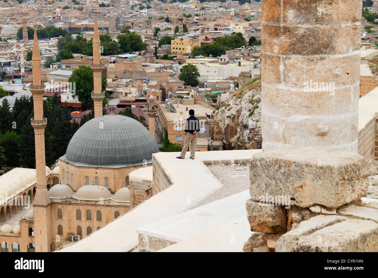 Overview of Urfa city and domes of Mevlid i Halil Camii mosque from the citadel with man staring at the horizon Stock Photo