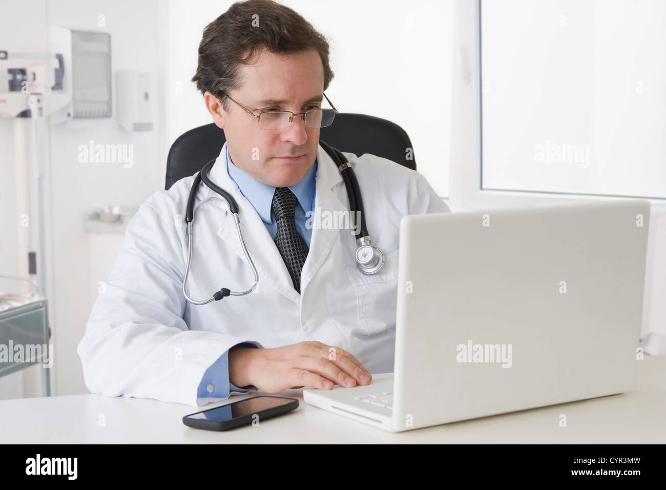 Doctor sitting desk reviewing hi-res stock photography and images - Alamy