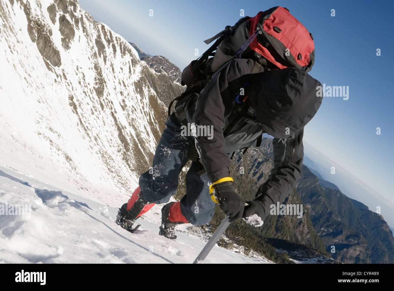 Mountain climber use ice axe to walk on snow ice slop in winter Stock