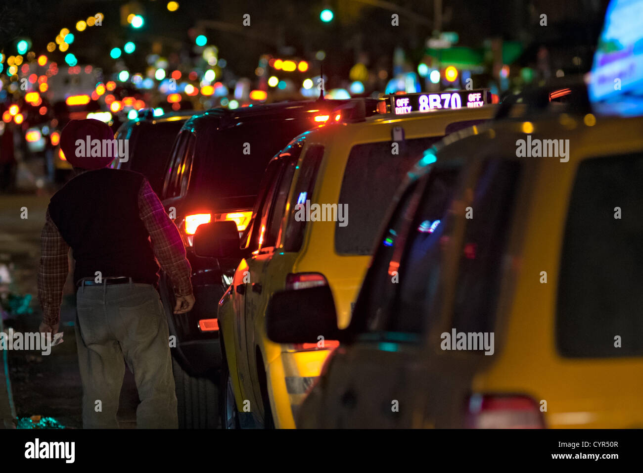 November 8, 2012, New York, NY, US.  A taxi driver checks the line ahead of him as he waits at the end of a three-block long line for gas in New York's Hell's Kitchen neighborhood, in the hours before gas rationing is to begin in the city due to continued gas shortages after Hurricane Sandy. Stock Photo
