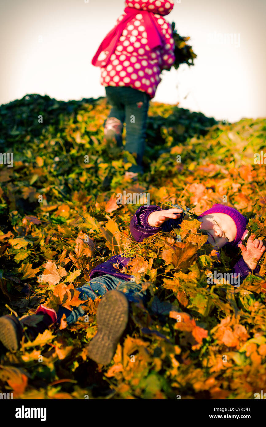 little girl lying in autumn leaves Stock Photo - Alamy