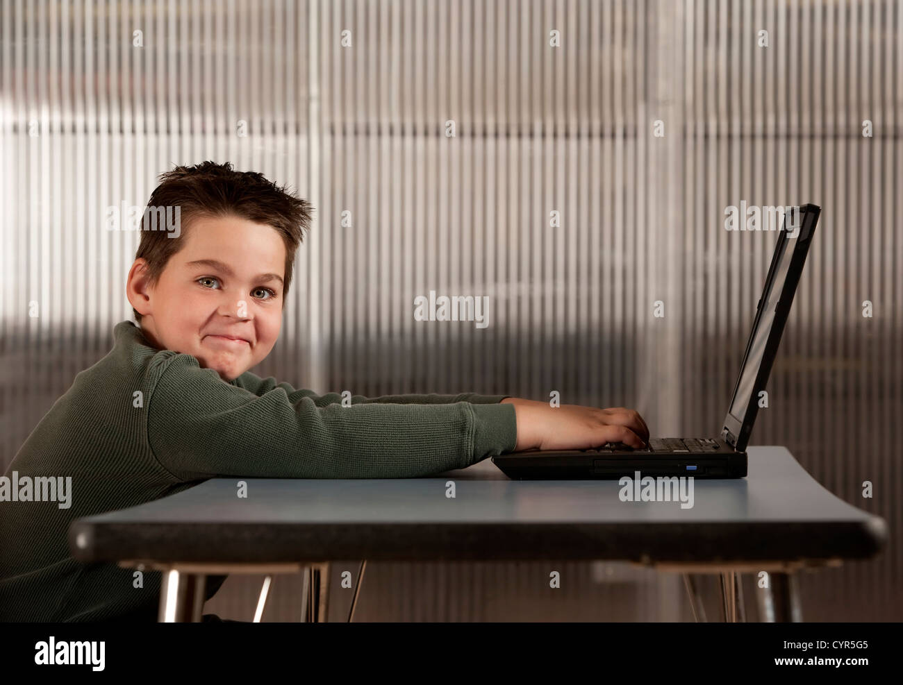 Cute young boy working on a laptop computer Stock Photo - Alamy