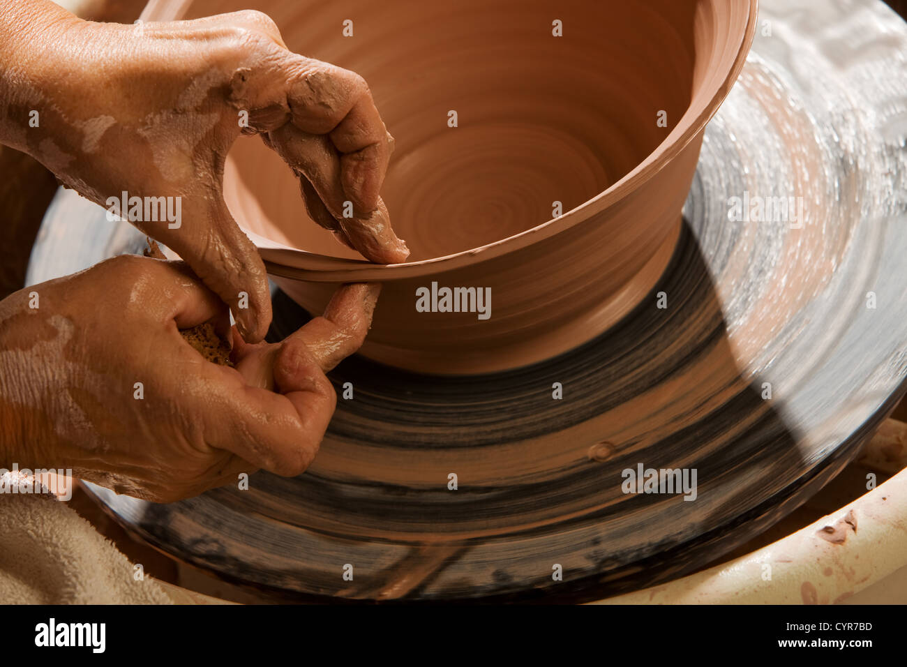 Closeup on hands of potter shaping clay on wheel Stock Photo