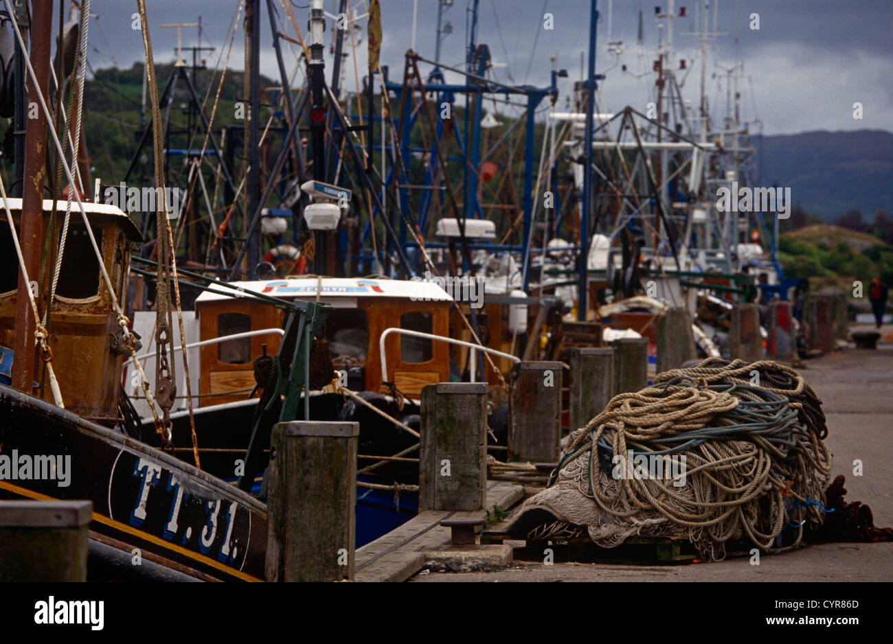 Fishing boats are moored up on the quayside at the village of Tarbert on the Mull of Kintyre, Scotland. Stock Photo