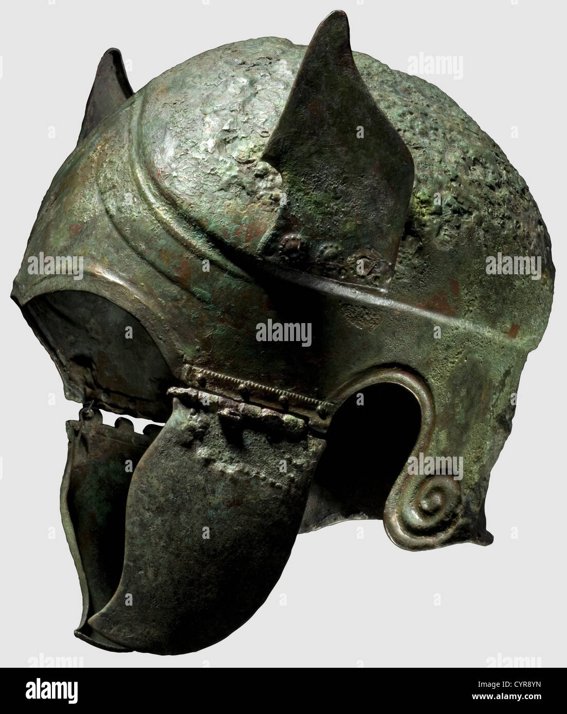 A Chalcidian type winged helmet,5th/4th century B.C.Bronze.Clearly offset dome,slightly carinated with double contoured forehead section with eyebrows,a short,pointed nose-guard,and embossed,stylised wings riveted to the sides with boss-shaped decorative rosettes.The edges of the wings flanged inward.Cusped cheekpieces,the plates for the tubular hinges with serrated edges.Moulded helmet perimeter with volutes embossed behind the ear cutouts.Slightly projecting neck guard rim.Height 27.7 cm.Height of the wings 11 cm.Width 6.5 cm.Weight 796 g.Gr,Additional-Rights-Clearences-Not Available Stock Photo