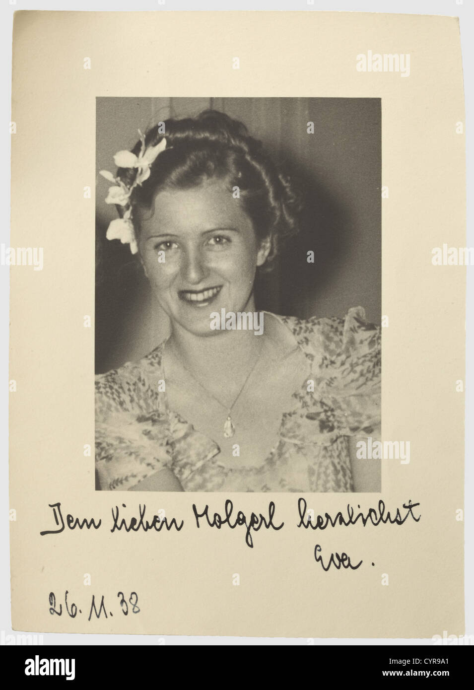 Eva Braun, a dedication photograph 26 November 1938 A portrait photograph, Eva Braun wearing a summer dress and a necklace, her hair pinned-up and decorated with blossoms. On the lower rim a handwritten dedication in dark ink 'Dem lieben Molgerl herzlichst Eva. 26.11.38' (To my dear Molgerl love Eva. 26.11.38). 18.7 x 13.7 cm. According to the family a friend of the family. To our knowledge a previously unknown photograph of Eva Braun, therefore especially rare, people, 1930s, 20th century, NS, National Socialism, Nazism, Third Reich, German Reich, Germany, Ger, Stock Photo