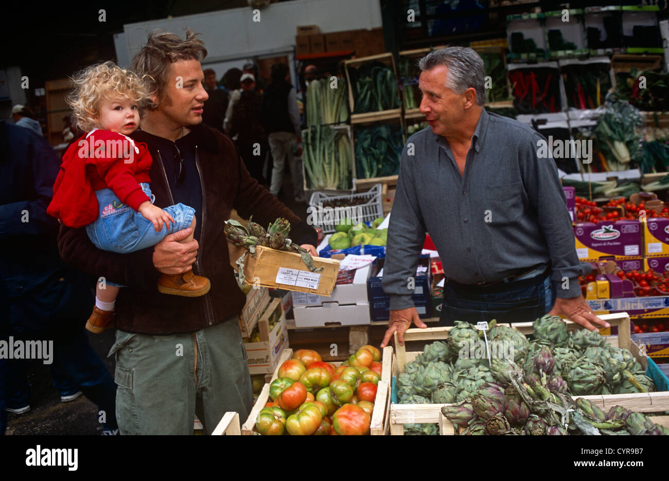 TV chef Jamie Oliver shops for produce with a favoured veg seller in Borough Market in Southwark, London. Stock Photo