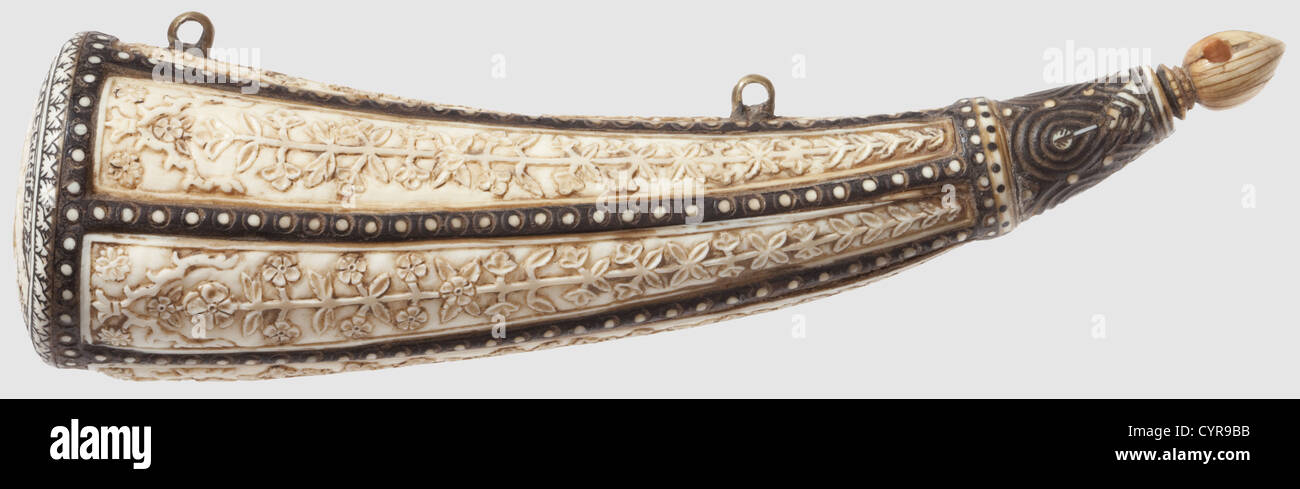 An Indian finely carved powder flask,Kota,17th century Conical horn body with six ivory strip inlays depicting fine floral relief carvings.The intermediate bars with ivory dot inlays.Carved nozzle with original ivory stopper.Finely carved base with central shield surmounting two lions flanked by rifles.Surrounding lacquer-inlaid banner with Devanagari inscription 'Shri Maha Roa Raja Ramsing ji jama silekhane Kota rajgar mai bana kai hokum se banai'(made by order of Shri Rao Raja Ram Singh ji in Kota armoury'.Two brass carrying loops.Well preser,Additional-Rights-Clearences-Not Available Stock Photo