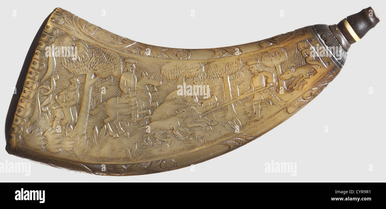 A carved powder horn,dated 1806 Compressed horn carved in relief on both sides,displaying hunting parties after wild boar and hare respectively. Inscribed on the narrow sides with: 'J.F. Götze fecit: Hohen Limburg' and 'Vivat es leben alle brave Jägers'(Long Live All Brave Hunters)respectively. The pinned horn base engraved: 'Gärtner J. Bremer 1806'. Carved dark horn spout without a stopper. Length 23.3 cm. Elaborately worked and in beautiful condition. 1,historic,historical,19th century,powder flask,accessory,accessories,military,militaria,object,,Additional-Rights-Clearences-Not Available Stock Photo