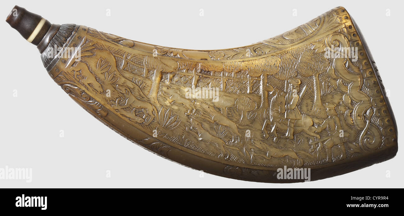 A carved powder horn,dated 1806 Compressed horn carved in relief on both sides,displaying hunting parties after wild boar and hare respectively. Inscribed on the narrow sides with: 'J.F. Götze fecit: Hohen Limburg' and 'Vivat es leben alle brave Jägers'(Long Live All Brave Hunters)respectively. The pinned horn base engraved: 'Gärtner J. Bremer 1806'. Carved dark horn spout without a stopper. Length 23.3 cm. Elaborately worked and in beautiful condition. 1,historic,historical,19th century,powder flask,accessory,accessories,military,militaria,object,,Additional-Rights-Clearences-Not Available Stock Photo