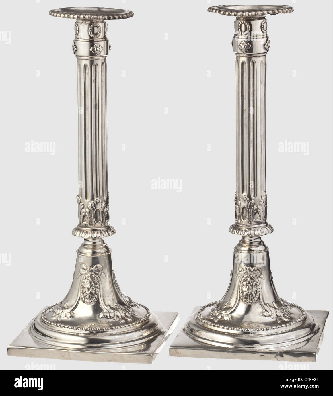 A pair of silver Empire candlesticks,Augsburg,circa 1785 Square plinths,the round candlestick feet decorated with garlands and flowers in relief.Fluted column shafts,inserted sockets with beaded edges.Each marked with the 'ICM' master's mark and the Augsburg inspection mark for the years 1785 - 87.The insert sockets bear Munich acceptance marks.Heavily cleaned,the edges of the plinths have been resoldered in places.Height of each 26.5 cm.Weight together 897 g.Johann Martin Langenbauer,active in Augsburg from 1747 to 1792.Cf.Rosenberg,vol.1,no.,Additional-Rights-Clearences-Not Available Stock Photo