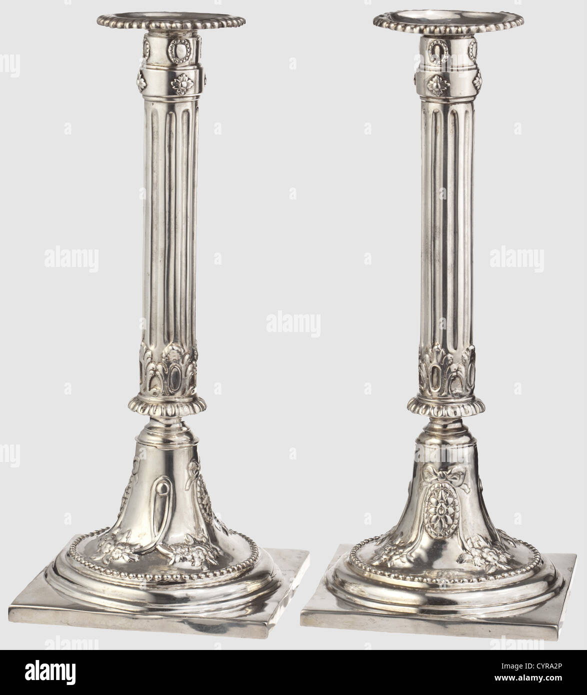 A pair of silver Empire candlesticks,Augsburg,circa 1785 Square plinths,the round candlestick feet decorated with garlands and flowers in relief.Fluted column shafts,inserted sockets with beaded edges.Each marked with the 'ICM' master's mark and the Augsburg inspection mark for the years 1785 - 87.The insert sockets bear Munich acceptance marks.Heavily cleaned,the edges of the plinths have been resoldered in places.Height of each 26.5 cm.Weight together 897 g.Johann Martin Langenbauer,active in Augsburg from 1747 to 1792.Cf.Rosenberg,vol.1,no.,Additional-Rights-Clearences-Not Available Stock Photo