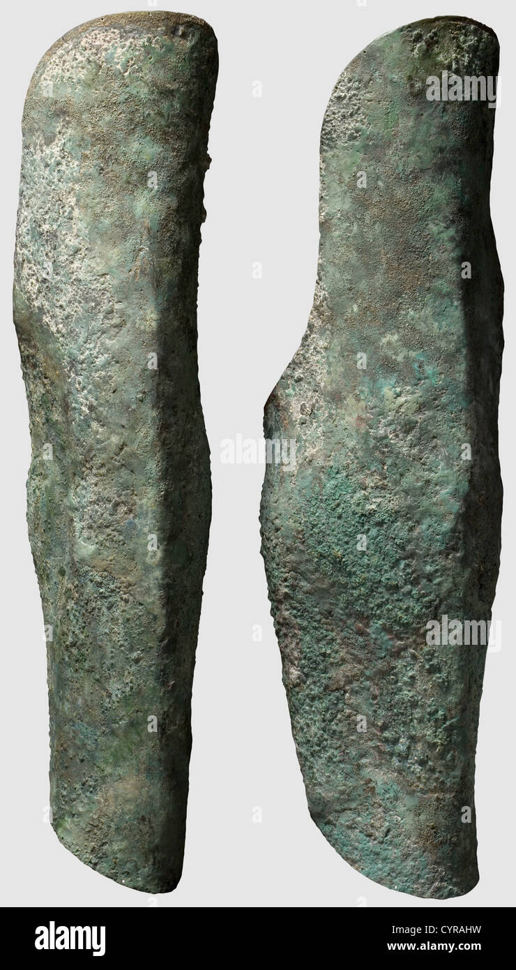 A pair of long Greek bronze greaves, 5th/4th century B.C. Anatomically  shaped, fine lining holes along the perimeter. Lengths 45 and 45.5 cm.  Greenish blue patina, heavily corroded with encrusted soil in