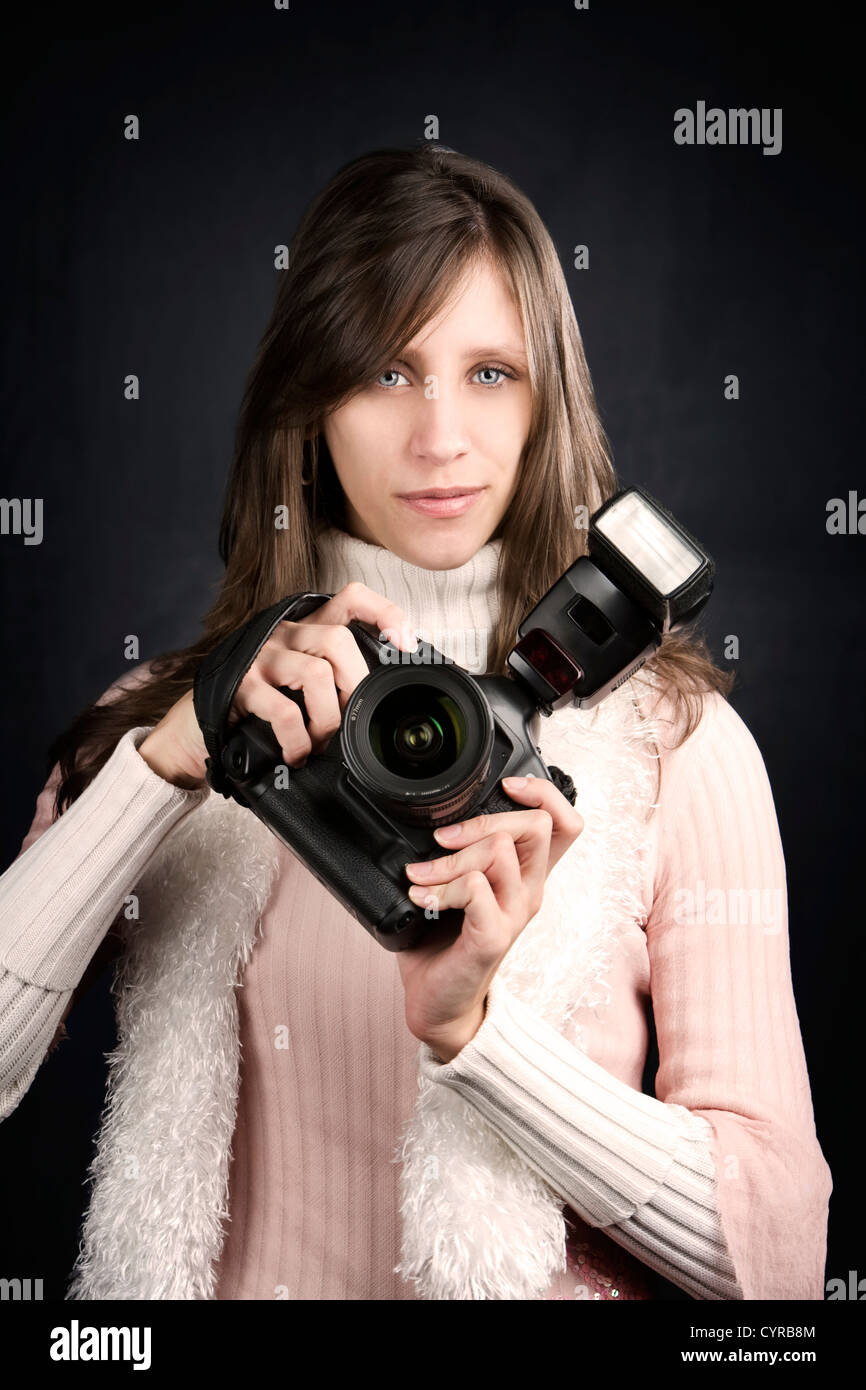 Pretty photographer with a professional camera and flash Stock Photo