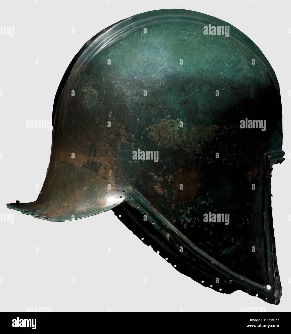 An Illyrian type helmet,6th century B.C.Bronze with fine green noble patina.Of domed form,the crown with two raised parallel ridges extending from front to back forming a crest base.A rectangular hole pierced at centre front for crest attachment.Rectangular face opening,the pointed cheekpieces with pierced holes for the chinstrap.Slightly flaring neck-guard.The edge bordered by a moulded rib and a row of pierced holes for lining attachment with partially preserved rivets.Small corrosion pits in some places,slightly torn at rear.Height 22 cm.Good me,Additional-Rights-Clearences-Not Available Stock Photo