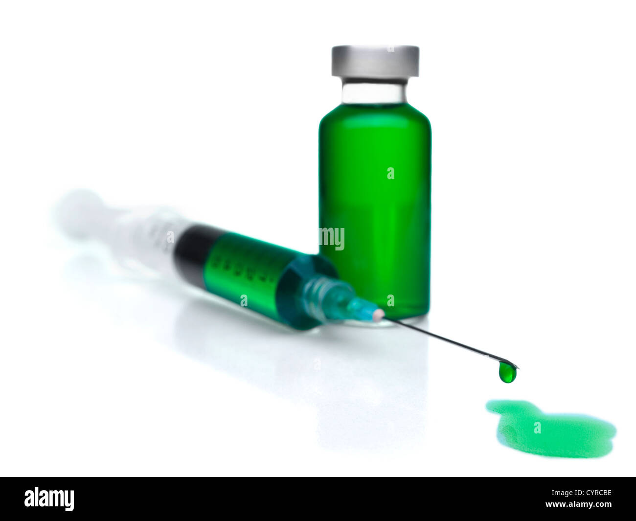 Close up of a syringe and a vial filled with green liquid. Stock Photo