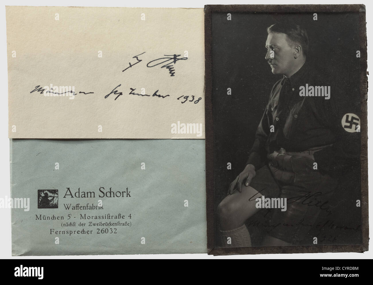 Adolf Hitler - Adam Schork, A signed portrait photograph from 1926 Early photograph by Hoffmann, Hitler in lederhosen, signed at the lower edge 'Adolf Hitler - München den 6/November 1926', a business card of Adam Schork on the reverse. Also another autograph 'Adolf Hitler - München September 1938' on a greeting card in a 'Wechselrahmen für Ansichtskarten. Hoch und quer zum Hängen' (Clip-on picture frame for picture postcards. To be put up vertical and horizontal) with galzed front and accordingly imprinted backside. The frame wrapped up in Schork's company pap, Stock Photo