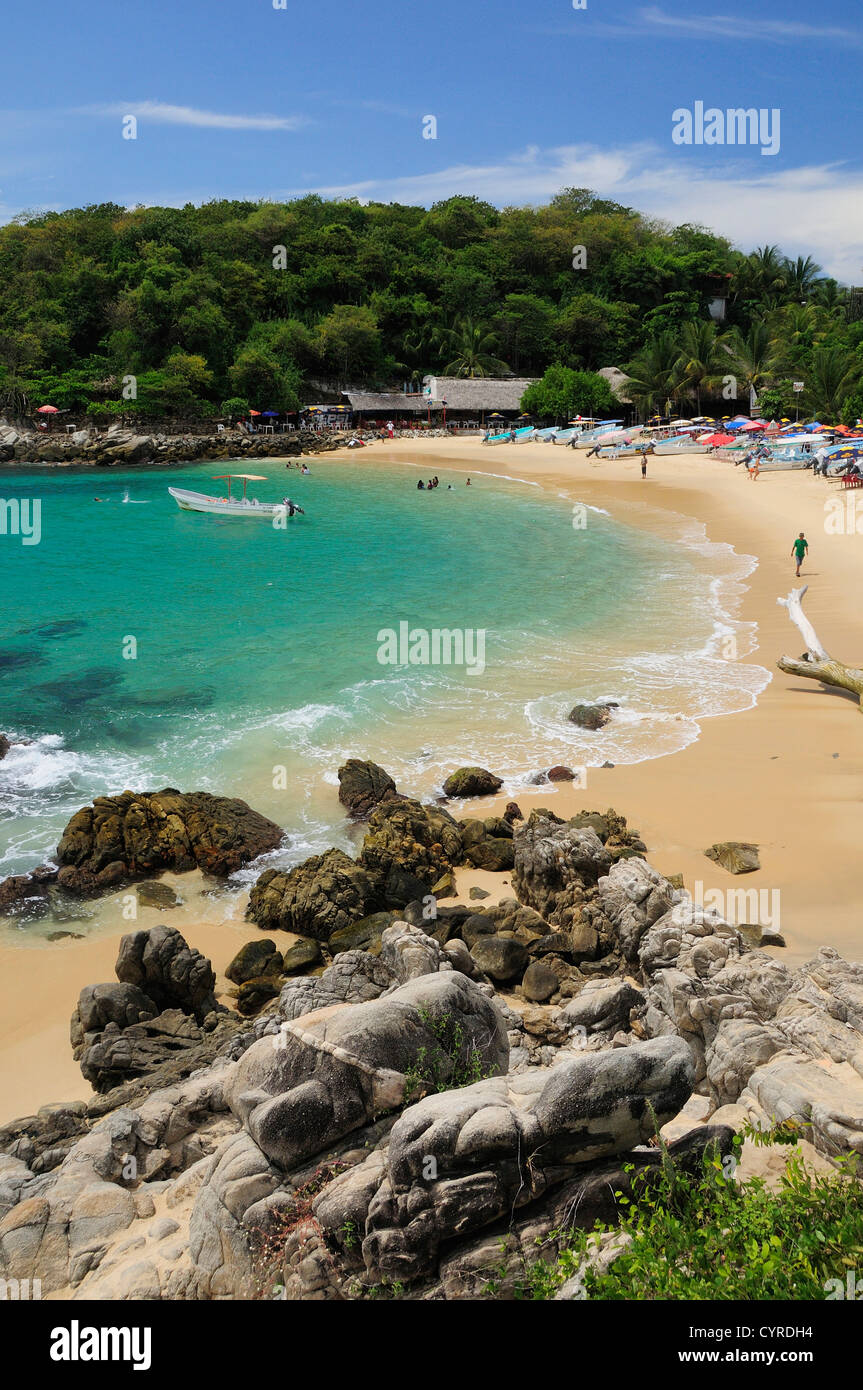 Mexico, Oaxaca, Puerto Escondido, View onto Playa Manzanillo sandy beach  with rocks in foreground and clear water Stock Photo - Alamy