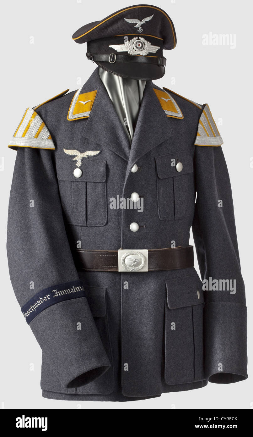 A uniform ensemble for a musician,in the band of the dive bomber wing 'Immelmann' Visor cap made of Luftwaffe-blue cloth with black mohair cap band,yellow piping(some damage by moths),metal insignia. Yellow cap liner with gold-embossed label 'Fewegla - Deutsche - Wertarbeit Erstklassig'(Fewegla - German - Workmanship - First Class),sweatband made of ersatz material. Tunic made of Luftwaffe blue woolcloth,brown liner,supply room stamps,size and maker's mark from Breslau 1938. Yellow collar patches,shoulder board piping and swallow's nests,silver braid,Additional-Rights-Clearences-Not Available Stock Photo
