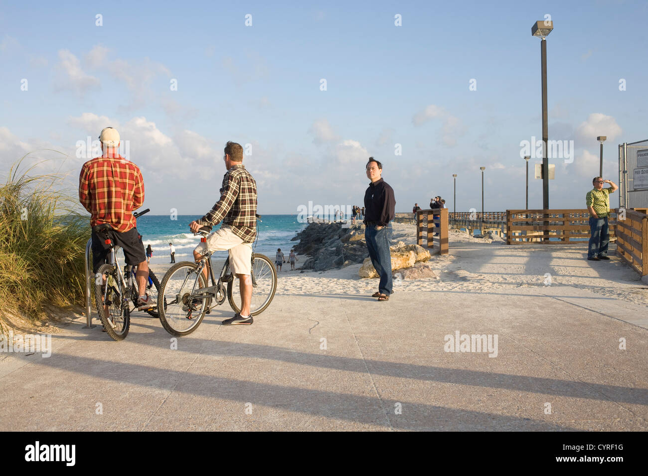 Cyclists chatting to one another at South-Point a favourite spot for cycle cruisers on Miami South Beach Stock Photo