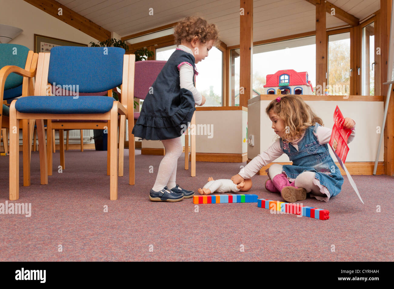Young children playing with toys in a Doctors surgery waiting area. Stock Photo