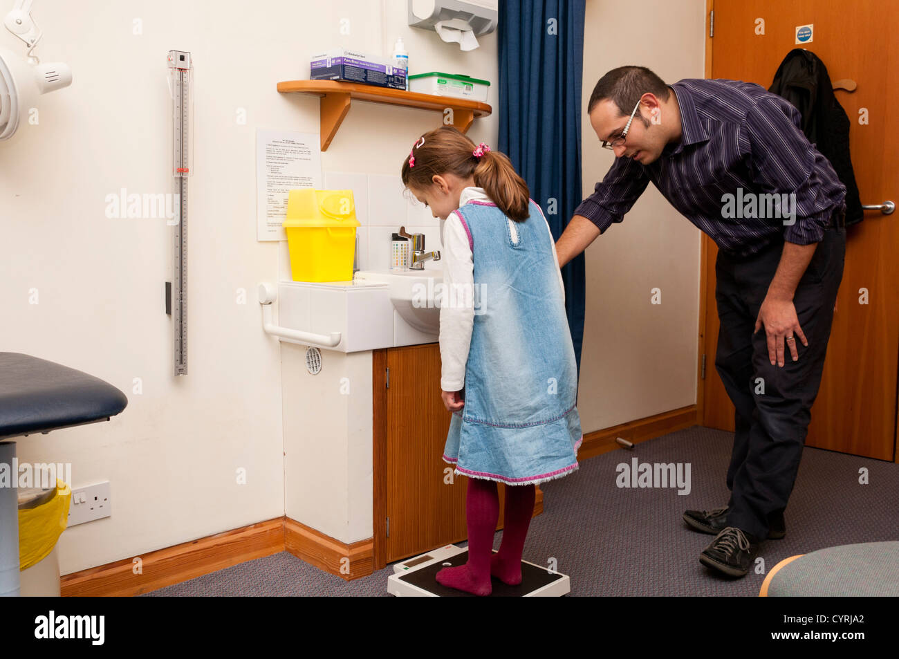 GP Doctor surgery patient consultation. Child weight measurement. Stock Photo