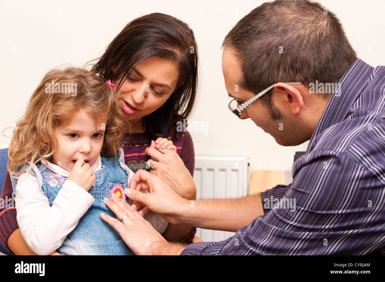 GP Doctor surgery patient consultation with young child who receives a bravery sticker. Stock Photo