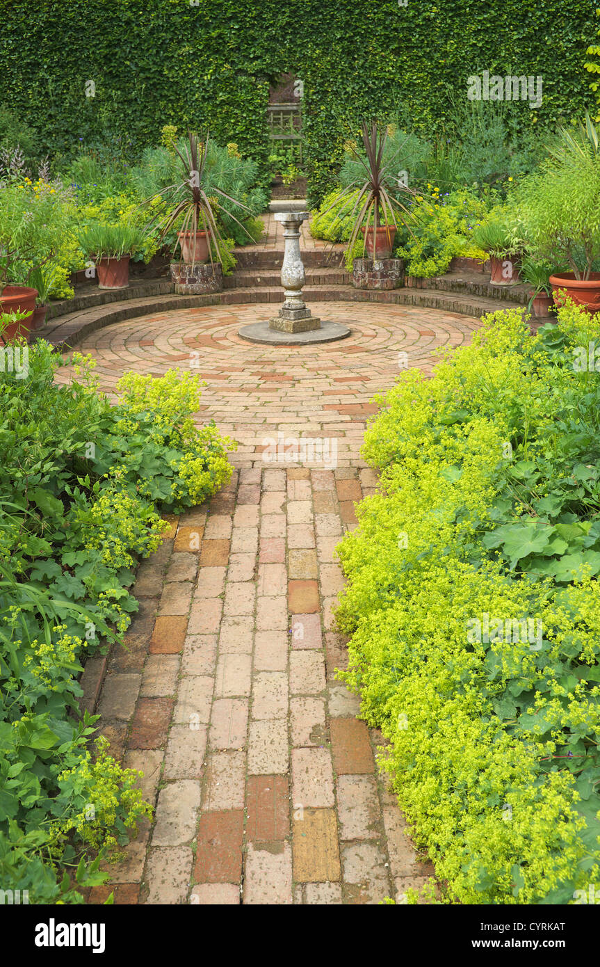 Paved brick garden path leading to Sundial in circular paved area