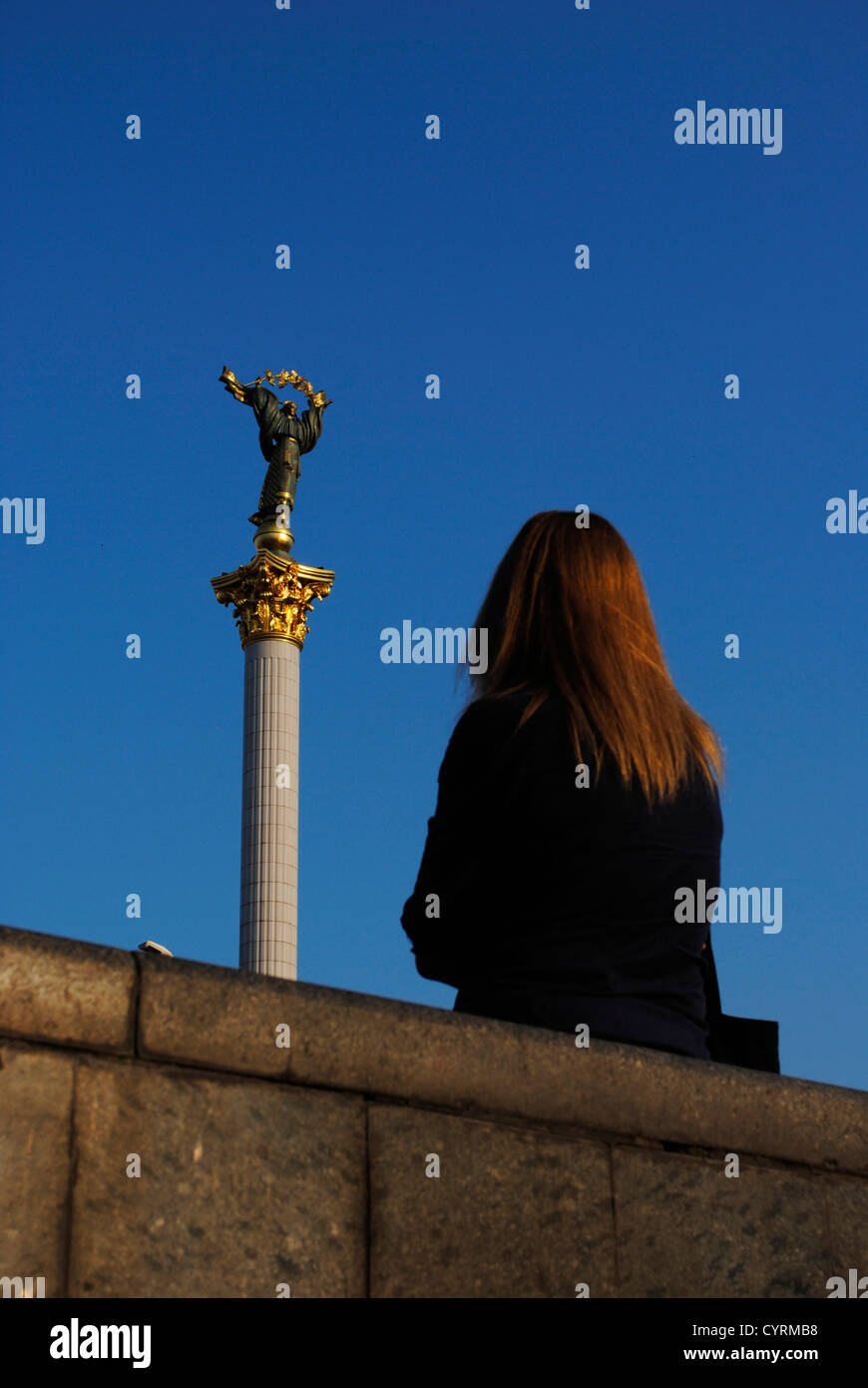 Ukraine. Kiev. Woman looking Independence Column with statue of Archangel Michael. Stock Photo