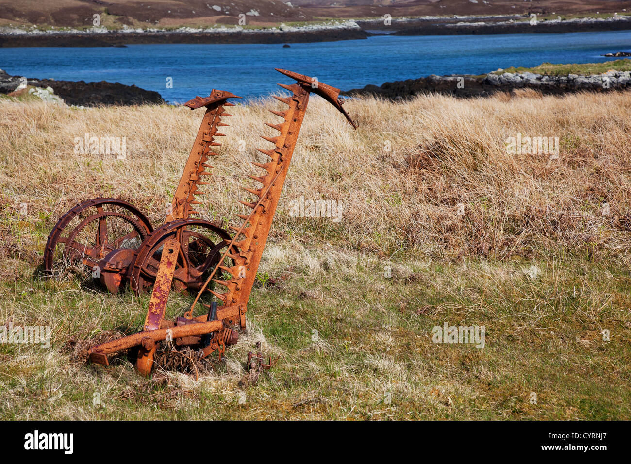 Abandoned rusty old farm machinery at Flodaigh on Benbecular, Outer Hebrides, Scotland, UK Stock Photo