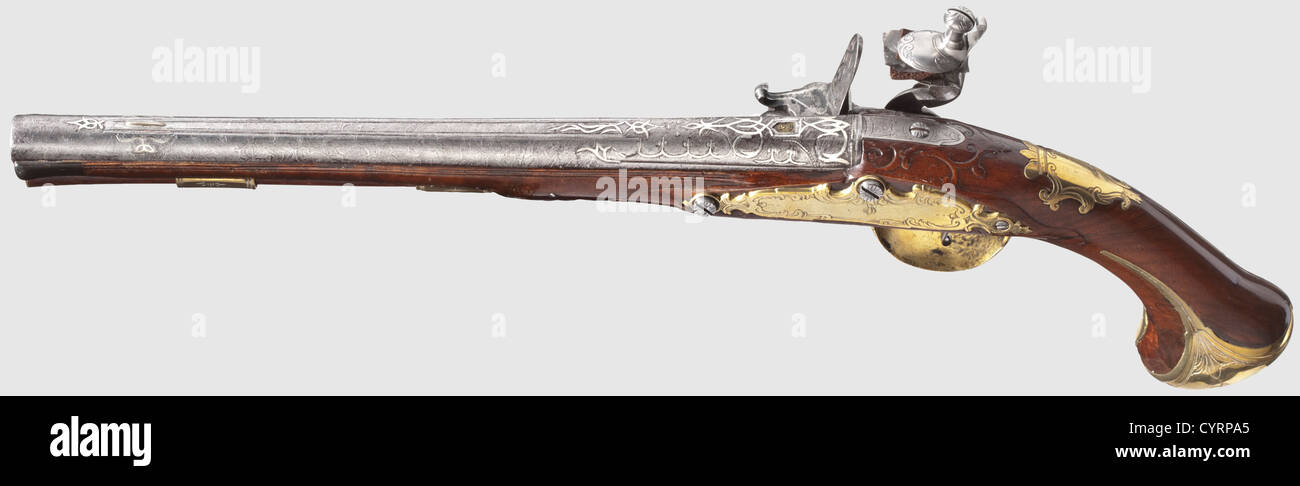 A long flintlock pistol,Nicolaus Koch,Vienna circa 1730.Round and smooth Ottoman Damascus barrel in 15 mm calibre with silver front sight on the midrib.At the breech palmette-shaped silver inlays with brass-lined Ottoman master's mark.Cut and engraved flintlock(the screw and the top cockjaw are good replacements)with signature 'NICOLAUS KOCH IN WIENN'.Carved walnut stock with horn nose and engraved brass furniture,the pommel cap with mascaron in relief.Later ramrod with brass plate.Length 49 cm.Nicolaus Koch,Vienna,mentioned 1715-32,fellow of the,Additional-Rights-Clearences-Not Available Stock Photo