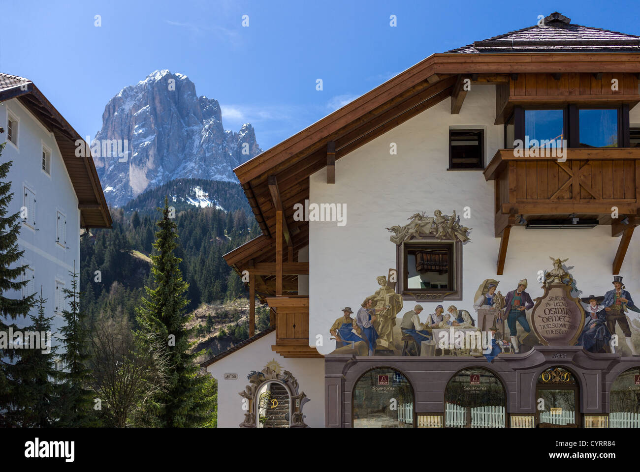 Italy, Dolomites, Santa Cristina, a fully decorated house of a craft store with the Sassolungo in the background. Stock Photo