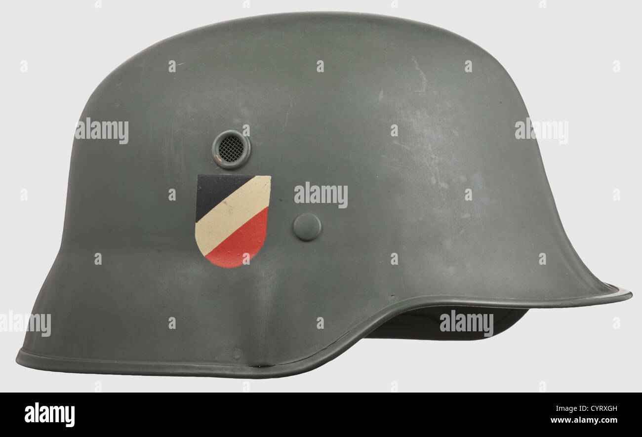A parade helmet M 1936 with two decals,maker Erel,Berlin Field-grey  lacquered fibre shell with riveted metal edges and ventilation holes,the  two decals almost completely intact. The helmet inside stamped "D.R.G.M.".  Brown sweat