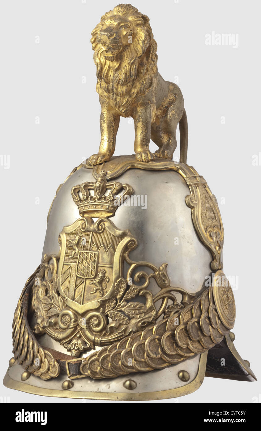 A M 1852 helmet,of Royal Bavarian Hartschiere Life Guards Version for enlisted men and sergeants in large parade version with rampant lion.Skull of nickel-silver with gold plated fittings,border and continuous rivets.Applied large helmet plate with Bavarian coat of arms surmounted by a crown.Chinscales with original leathering on embossed crown rosettes(strap added).The cruciform base plate richly decorated with ornaments and made of several pieces,a striding lion with struck number '29' under left front paw and no.'49' on inside of,Additional-Rights-Clearences-Not Available Stock Photo