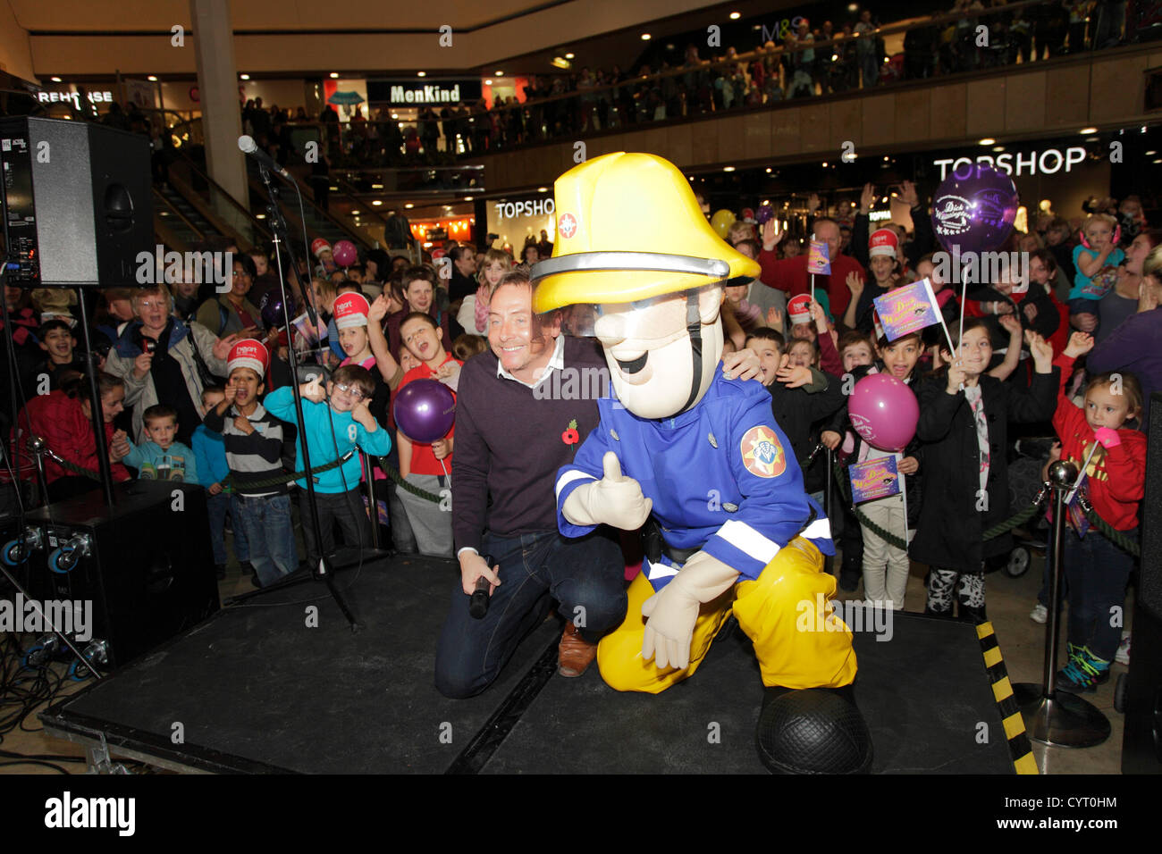 Kev Lawrence ( Heart FM Radio DJ ) and Fireman Sam puppet, at the switch on of Queensgate shopping centres Christmas lights, Peterborough, Cambridgeshire, England. 08 11 2012 Stock Photo