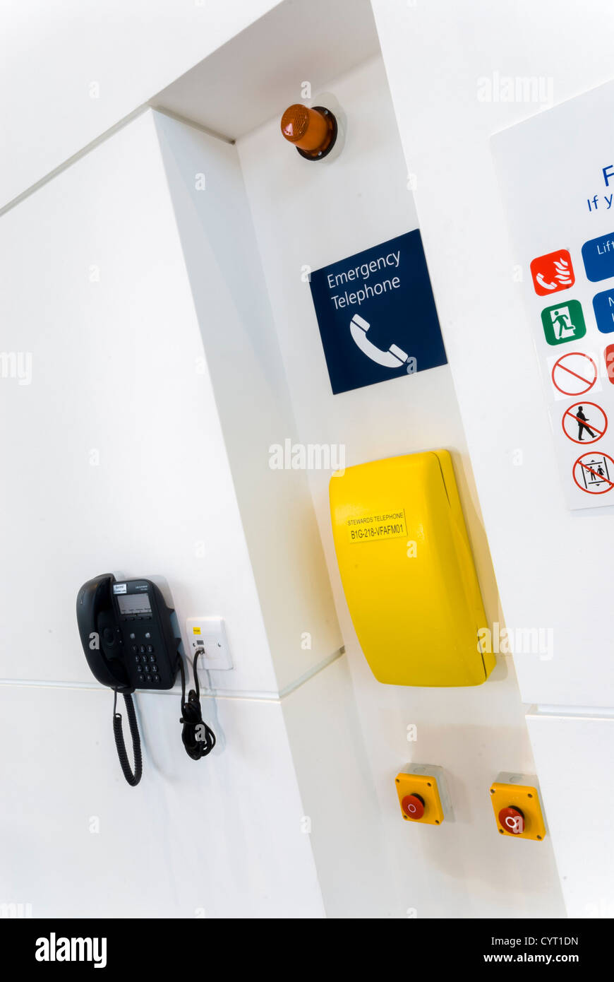 yellow emergency telephone on wall with "what to do in a fire" sign Stock Photo